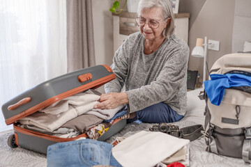 Travel and luggage concept, elderly woman ready to leave for journey after preparing luggage case...