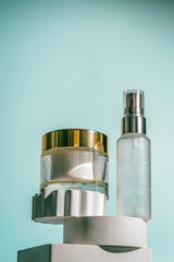 A soothing cream and a peptide serum are displayed on sculpted white pedestals with a flowing aqua...