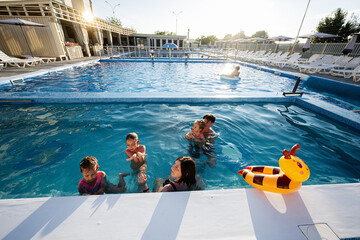 Family Enjoying a Sunny Day at a Modern Pool Facility