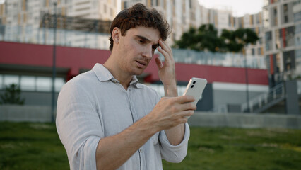 Caucasian man using mobile phone smartphone read bad news loss frustrated upset male stressed guy...