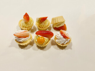 Delicious mini fruit tarts arranged next to each other, with one flipped over.