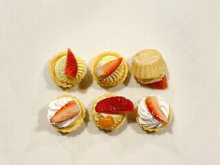 Delicious mini fruit tarts arranged next to each other, with one flipped over.