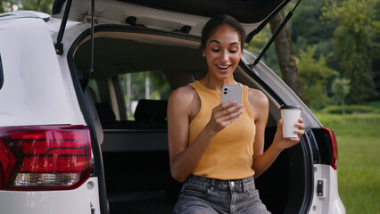 African American woman drinking coffee smiling relaxing happy female girl holding mobile phone...