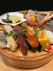 Sushi set with assortment of nigiri sushi, and some sashimi at the back.