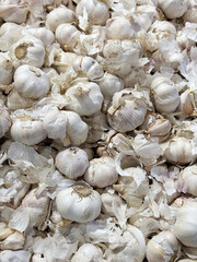 A pile of white garlic bulbs, being sold in a supermarket.