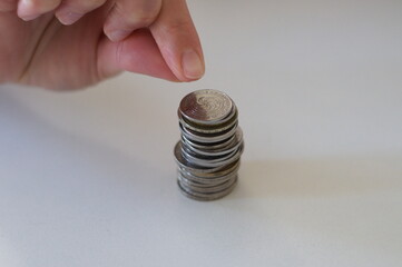 close up hand stacking coins on white background
