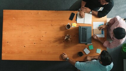 Top down aerial view of business team looking at financial graph while shaking hands for making...