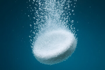 Fototapeta premium Effervescent Tablet Dissolving: A macro shot of an effervescent tablet submerged in water, releasing a cascade of bubbles, illustrating the process of dissolution in a refreshing and dynamic way.