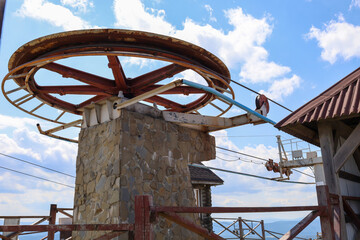 A mighty metal wheel with visible signs of time and environmental impact, mounted on a stone base....