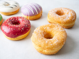 Donuts with different colorful icing designs on a white background.
