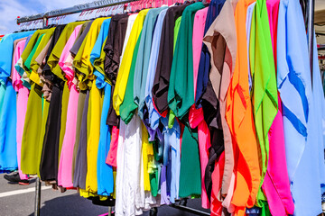 Colorful display of clothing on hangers in a retail store showcasing a variety of styles and...