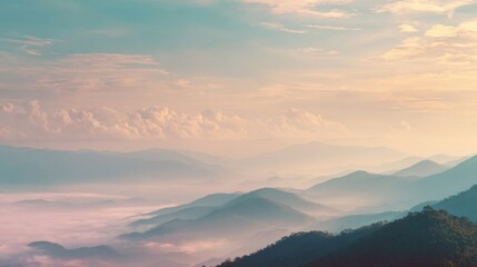 Fototapeta premium Breathtaking panoramic view of misty mountain landscape during sunrise with vibrant sky and clouds.