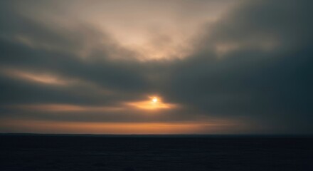 Obraz premium Golden Dawn: A breathtaking, serene image captures the tranquil beauty of the sunrise or sunset, with a glimpse of a golden sun emerging between dramatic clouds.