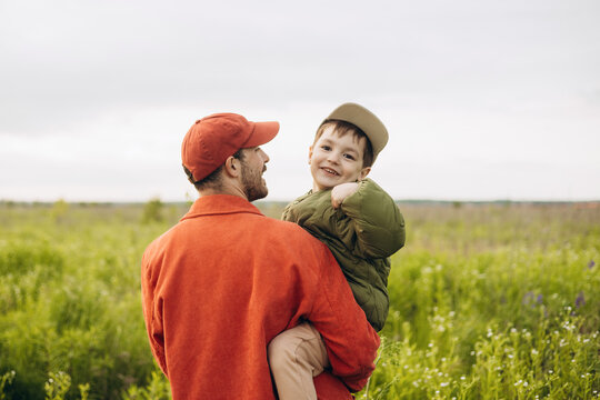 Father and son enjoying a walk in a sunny field