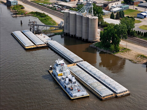 Aerial view of grain elevators with a tug boat getting ready to transport loaded grain barges