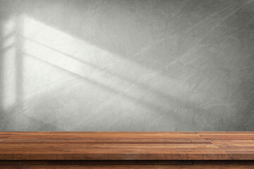 A wooden tabletop with a white wall and sunlight shining through the window.