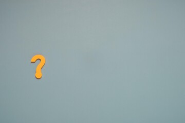 Bright yellow question mark on left of smooth, muted blue with copy space. Ideal for uncertainty, inquiry, problem solving, FAQs, and seeking answers.