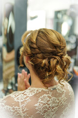 An elegant wedding hairstyle with soft curls and a twisted low ponytail. A romantic hairstyle, perfect for a wedding, with natural volume and texture. Ideal for modern and sophisticated brides.