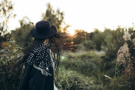 Woman in hat enjoying serene sunset in nature