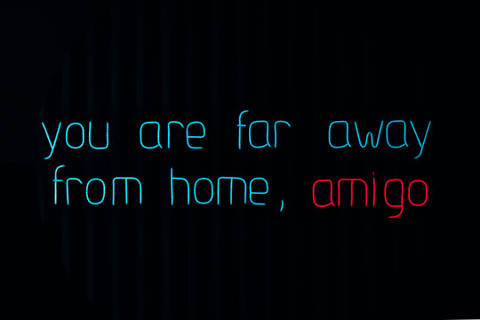Neon sign with text about being far from home