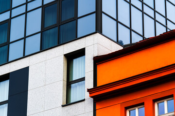 Modern Building Facade with Bold Orange Panels and Contrasting Gray Metal Wall