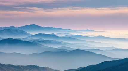 Obraz premium Scenic Misty Mountain Range during Sunrise with Soft Clouds and Fog in Nature.