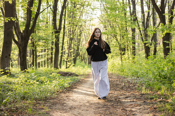Girl running in park in the morning, teenage girl jogging in forest.