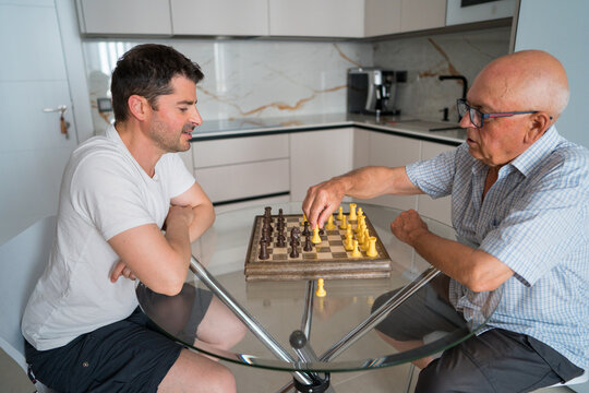 Father and son enjoying a chess game at home