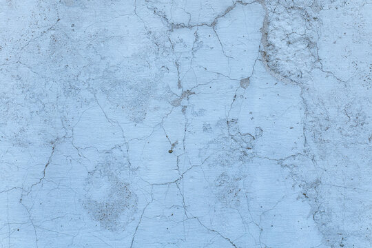 Close up of cracked concrete surface in blue-gray tones