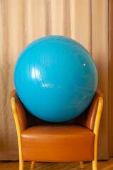 Blue gym ball rests on the armchair in the living room