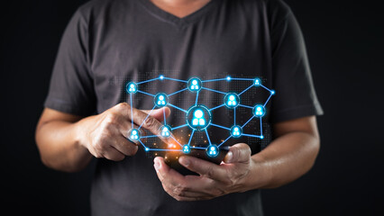 A person interacts with a smartphone, displaying a glowing digital network of connected user icons symbolizing social network connectivity, communication, and global online interaction via technology.