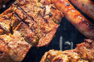 Pork chops, steak, sausages on barbecue grill