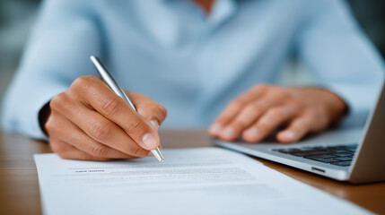 A hand pointing at a printed job description document with a pen, positioned above a laptop keyboard, highlighting the hiring process and employment screening employment document,