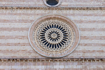 Facade with rose window of Basilica of Saint Clare, gothic roman catholic church, Assisi, Italy