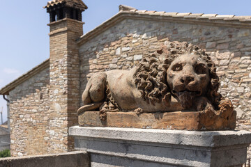 Statue of Lion outside Basilica of Saint Clare in square Saint Clare, symbol of guardianship and power, Assisi, Italy