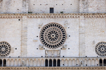 Decorative facade with rose window of romanesque 12th century Assisi Cathedral, Assisi, Italy