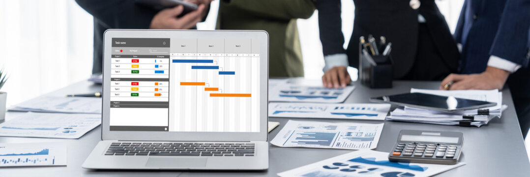 Project planning software for brisk business project management on the computer screen showing timeline chart of the team project