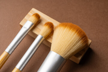 Bamboo makeup brushes on brown background