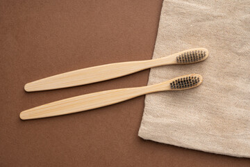 Top view of bamboo toothbrushes with beige fabric background
