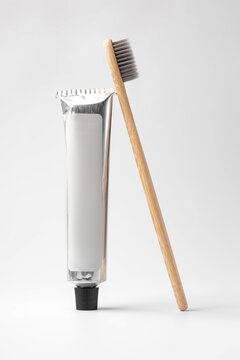 Bamboo toothbrush and toothpaste on neutral background