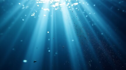 Obraz premium Underwater sunbeams piercing deep blue ocean water surface light