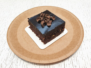 Chocolate slice of cake, brownie brownie on a plate. Chocolate dessert in a cafe, restaurant.