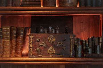 antique wooden chest along with books and old objects on wooden shelves