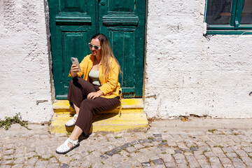 Woman sitting on a street using smartphone travel photo