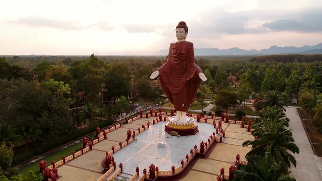 Majestic buddha statue in Wat Bang Thong temple, Krabi, Thailand, a peaceful landscape during a vibrant sunset. Popular religious site of krabi province.