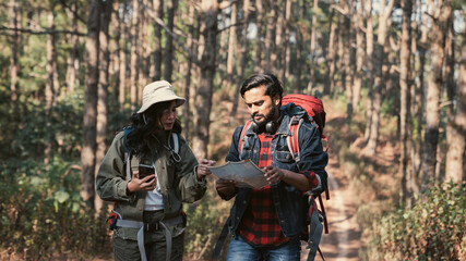 A couple is hiking along a forest trail on a beautiful day, enjoying nature and their outdoor adventure perfect for themes of travel, hiking, and togetherness.