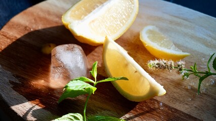 Fresh lemon slices with ice cubes and mint leaves on a wooden surface. Ideal image for summer...