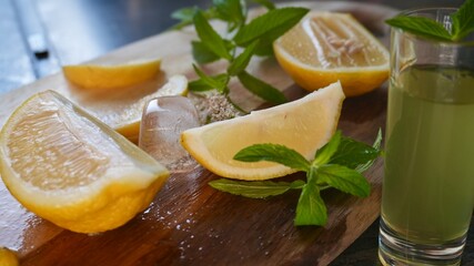 Fresh lemon slices with ice cubes and mint leaves on a wooden surface. Ideal image for summer...