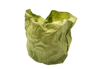 a green paper bag is sitting on a white surface