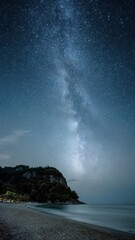Midnight summer beach landscape with milky way over calm waters Generative AI
